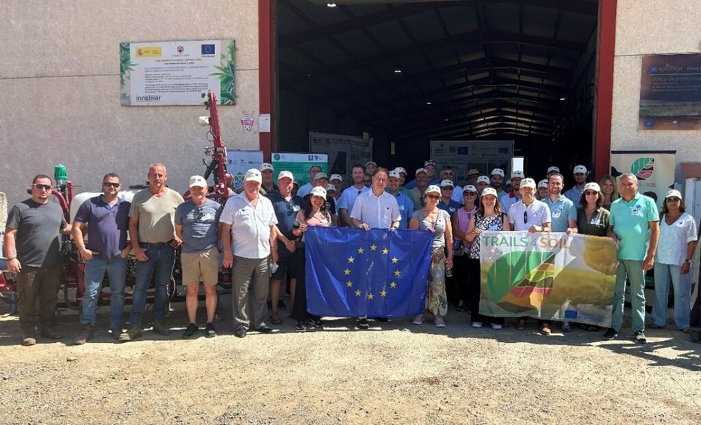 A group of people stood by the opening of a barn