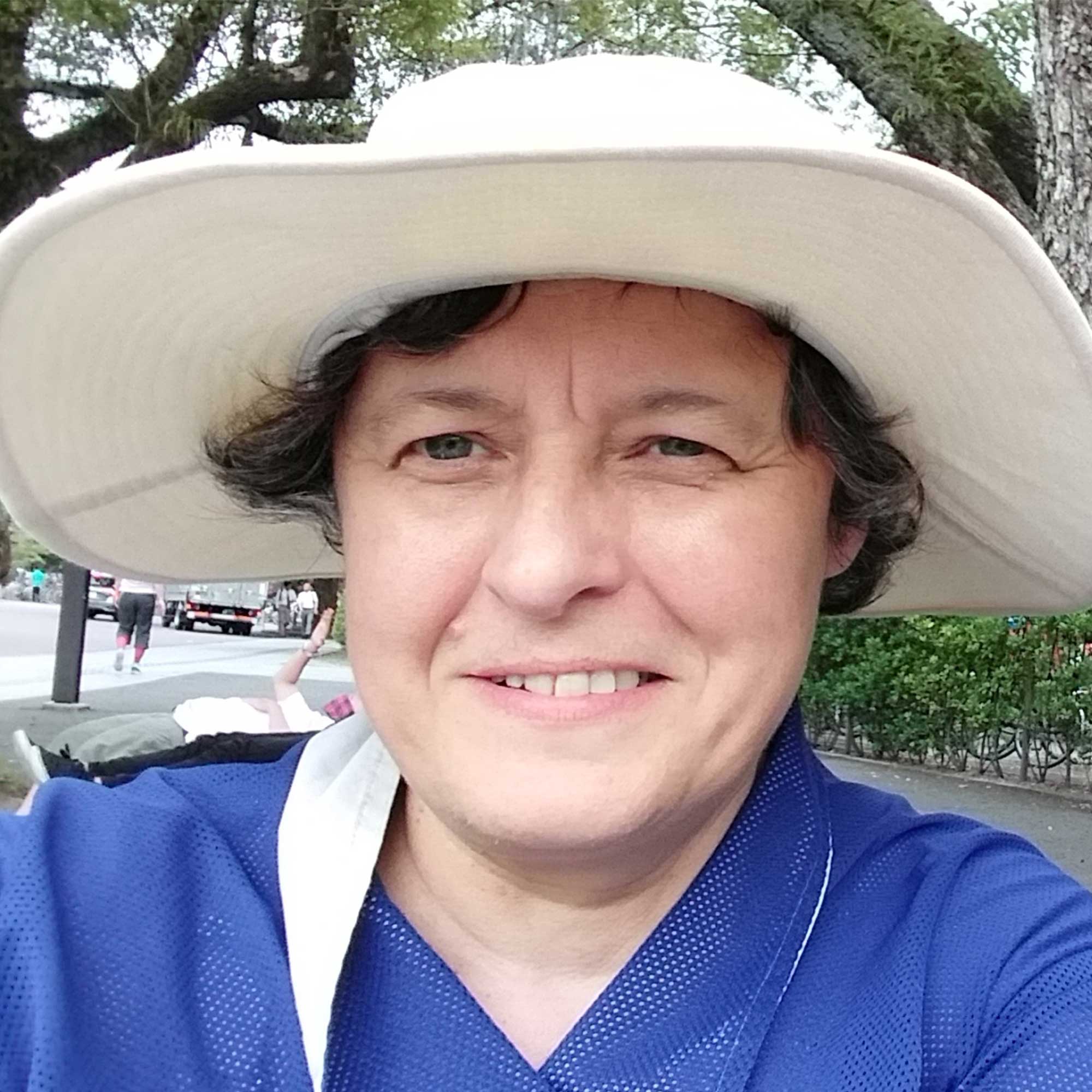 Lois Mansfield smiling wearing a hat.